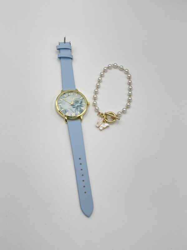 Style et Design : Cette montre ronde à quartz présente un cadran délicatement imprimé de fleurs, apportant une touche de fraîcheur et de féminité. Son bracelet bleu en cuir PU se marie parfaitement avec le design floral, créant un ensemble parfait pour des journées décontractées ou des vacances. Le bracelet assorti complète l'ensemble, ajoutant une note personnelle et tendance à votre look. Matériaux et Confort : Boîtier : Fabriqué en alliage de zinc, pour une montre légère mais robuste. Bracelet : Cuir PU bleu, agréable à porter et ajustable pour un confort optimal. Verre : Verre synthétique pour protéger le cadran tout en restant léger. Caractéristiques : Alimentée par pile bouton, assurant une précision fiable. Non étanche, à porter dans des conditions sèches pour préserver sa qualité. Design élégant et floral, parfait pour le printemps et l'été. Dimensions : Taille du boîtier : Adaptée à la plupart des poignets féminins. Bracelet ajustable pour s'adapter à différentes tailles de poignets.